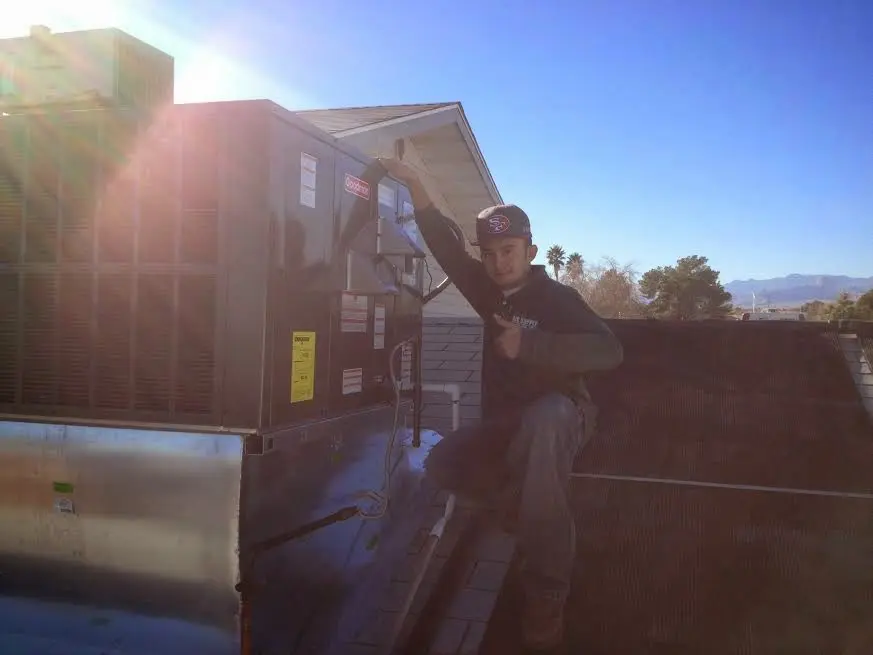 HVAC technician performing Boiler Repair on a rooftop unit in Kennett
